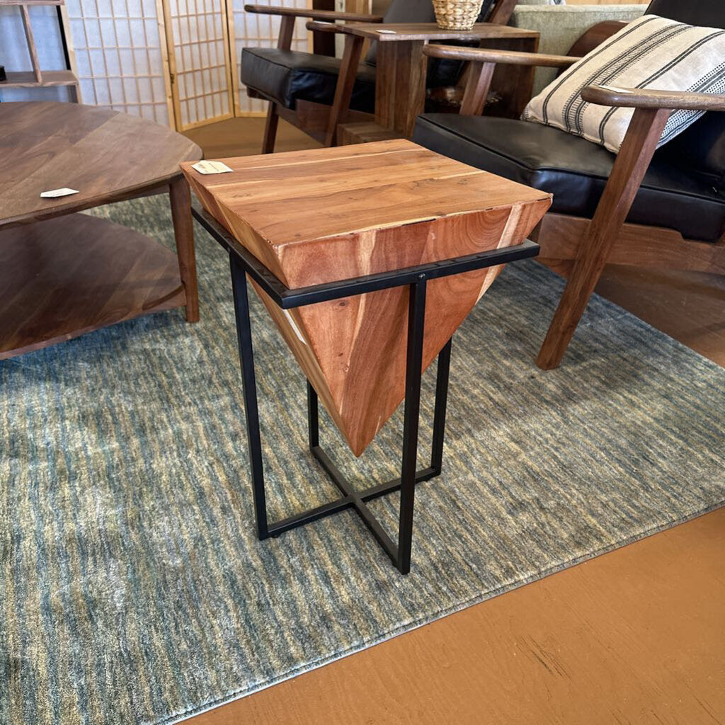 Wooden side table with black metal legs on a patterned rug