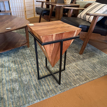Wooden side table with black metal legs on a patterned rug