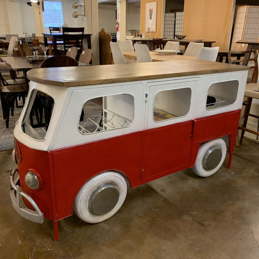 Red and white van-shaped table in a room with chairs and tables.