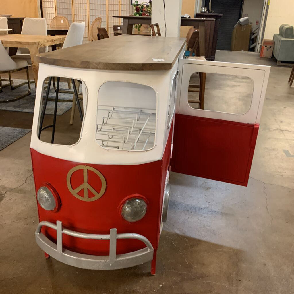Red and white vehicle-shaped table with open door in a room with tables and chairs.