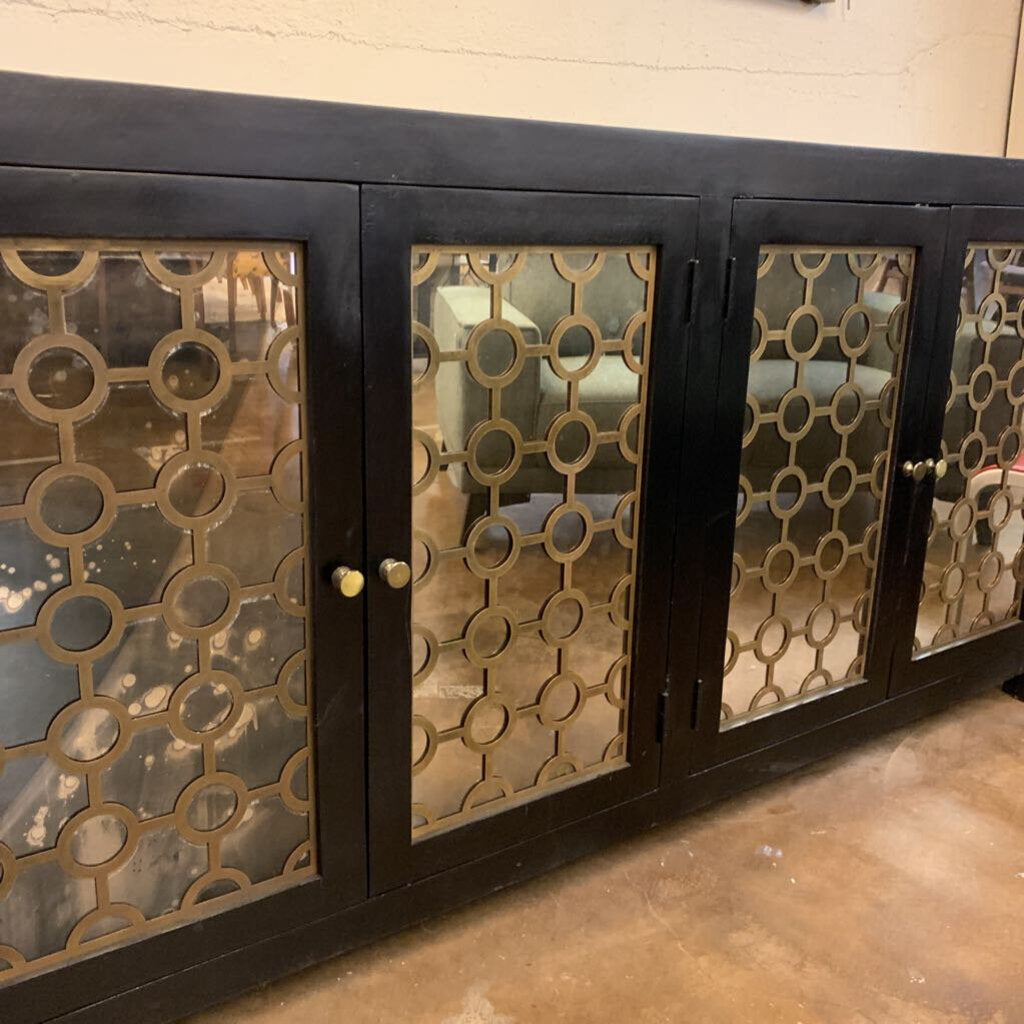 Cabinet with decorative glass panels and metal frame on a concrete floor.