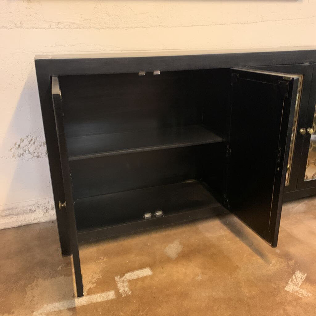 Black metal cabinet with open door on a concrete floor.