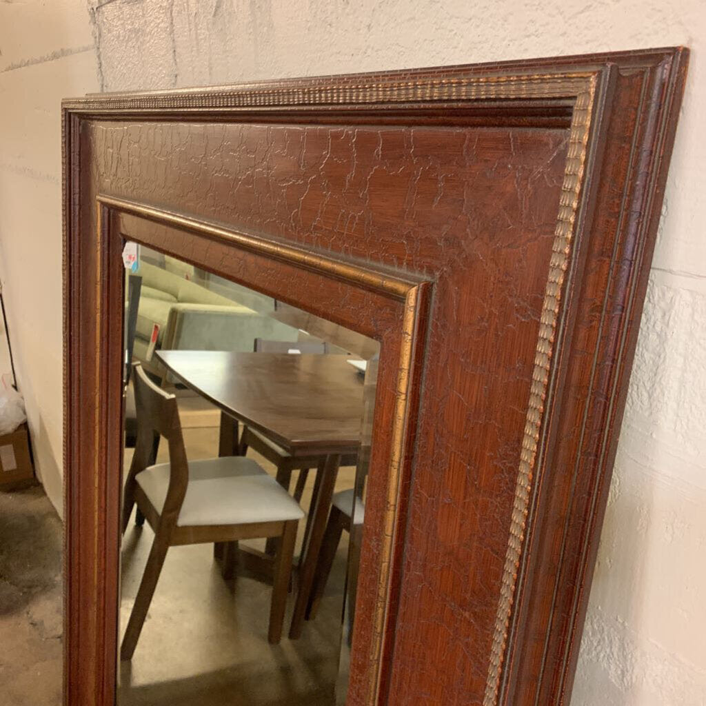 Wooden framed mirror reflecting a dining room setting