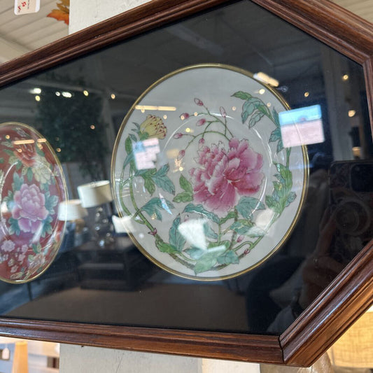 Decorative plates with floral designs in a wooden frame.