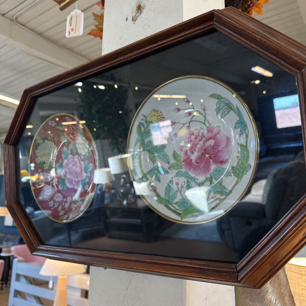 Decorative plates with floral designs in a wooden frame.