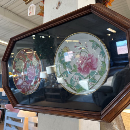 Decorative plates with floral designs in a wooden frame.