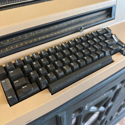Close-up of a black keyboard on a beige surface with a metallic frame.