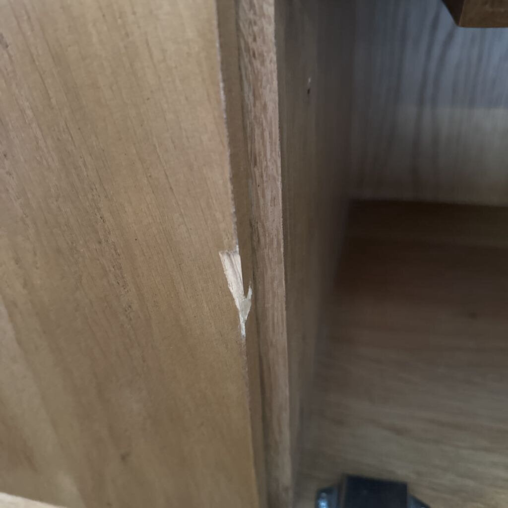 Close-up of a wooden shelf corner with a small gap.
