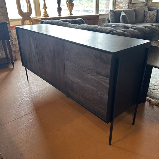 Long dark gray sideboard in a room with a sofa and decorative items.
