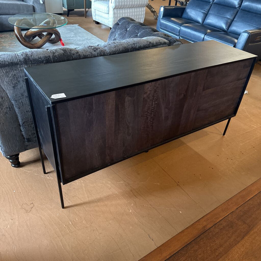 Dark wooden console table in a room with gray sofas and a blue couch.