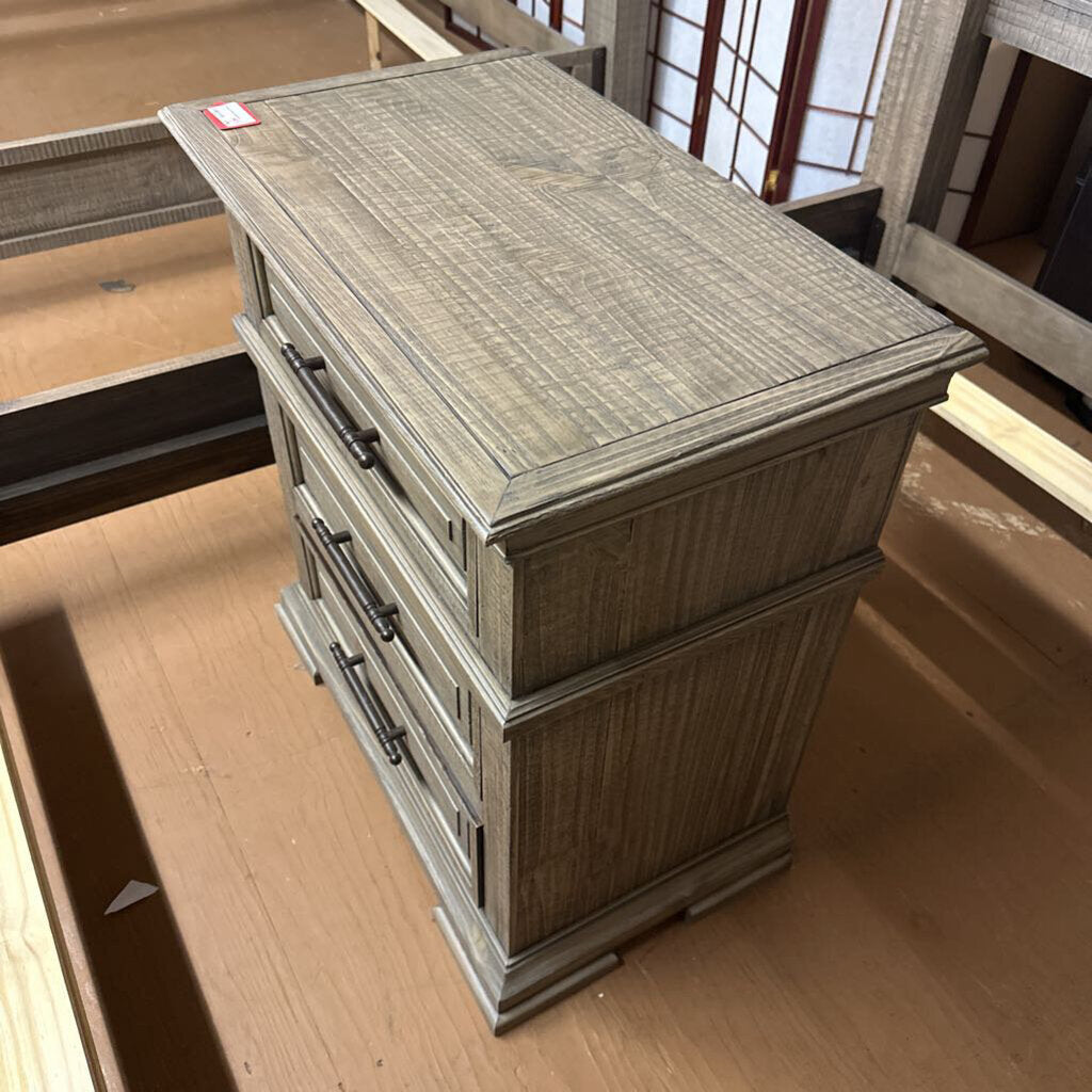 Wooden nightstand with three drawers on a wooden floor