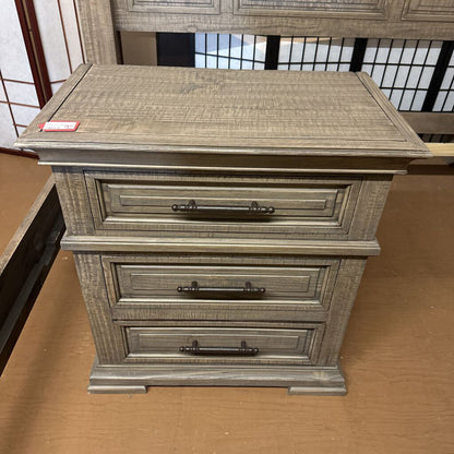 Wooden nightstand with two drawers on a cardboard surface