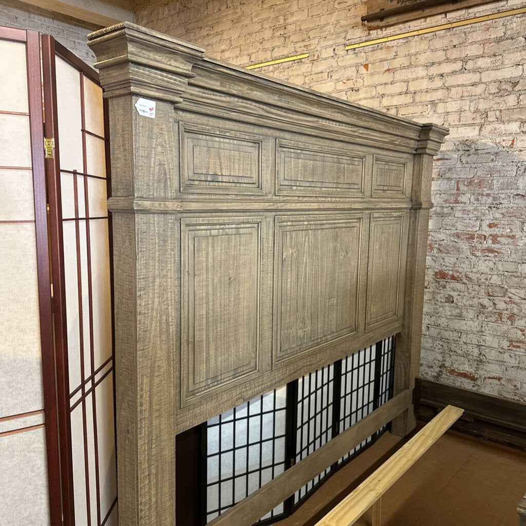 Wooden headboard against a brick wall