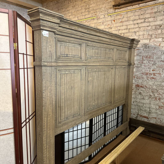 Wooden headboard against a brick wall