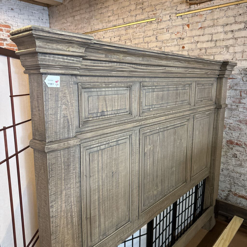 Wooden headboard against a brick wall