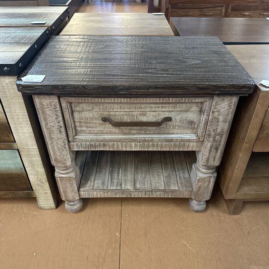 Wooden side table with a drawer in a store setting