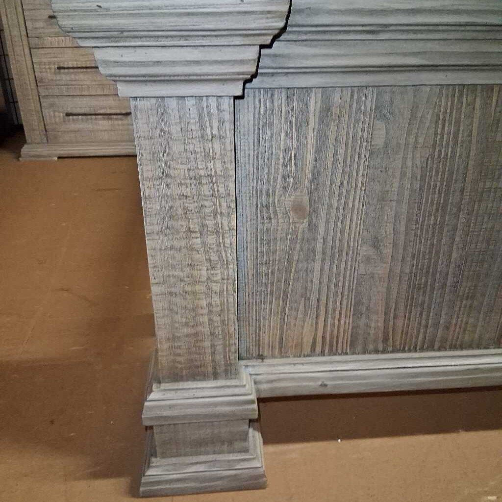 Wooden headboard with a textured finish on a brown surface