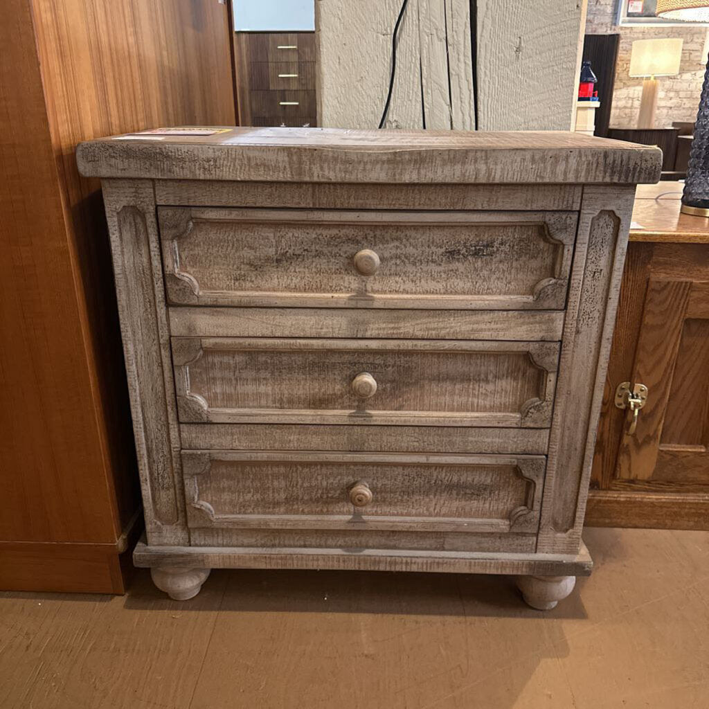 Wooden dresser with three drawers in a room setting