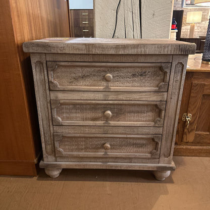 Wooden dresser with three drawers in a room setting