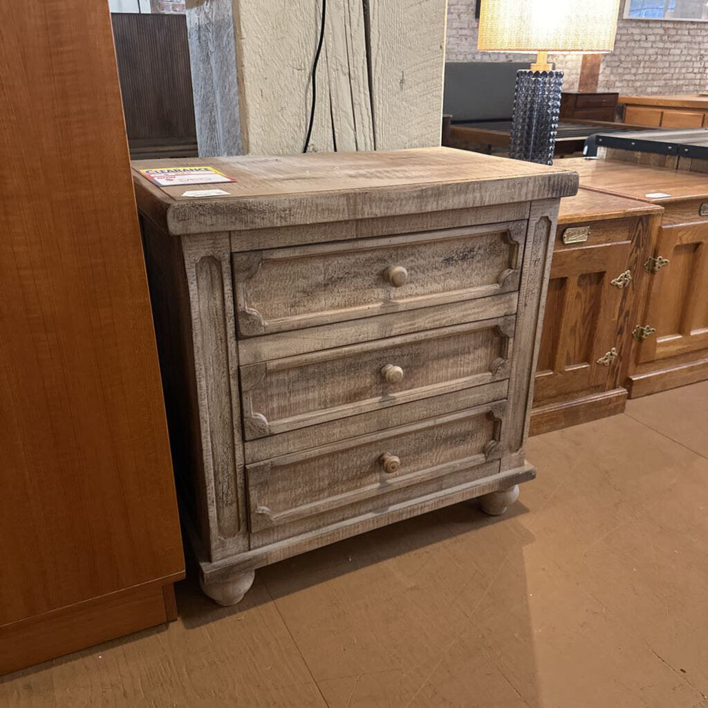 Wooden dresser with three drawers in a showroom setting