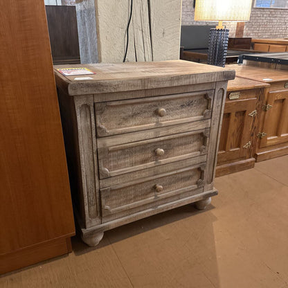 Wooden dresser with three drawers in a showroom setting