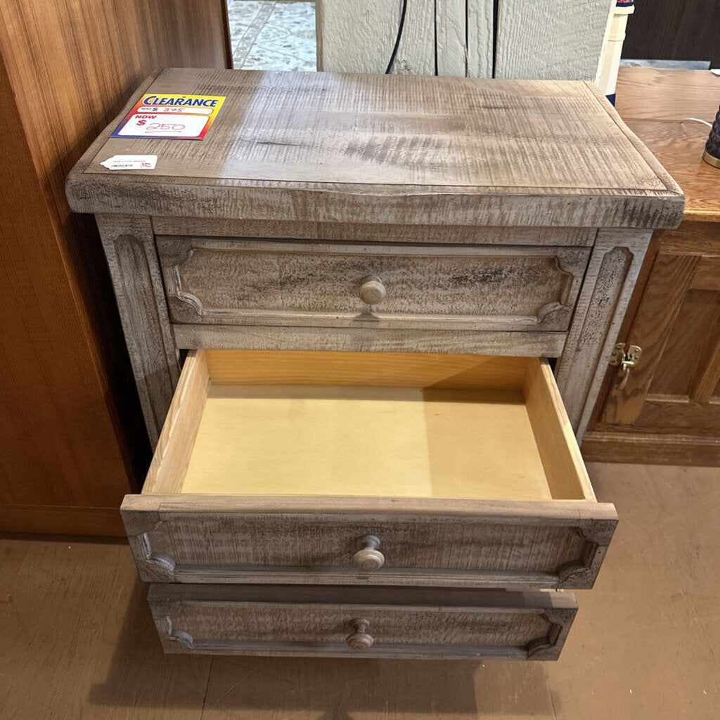 Wooden nightstand with open drawer in a room setting