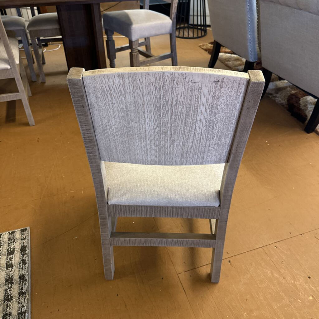 Gray chair with a textured backrest and seat on a wooden floor.