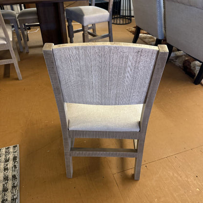 Gray chair with a textured backrest and seat on a wooden floor.