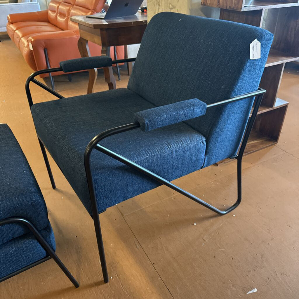 Blue armchair with black metal frame on a wooden floor