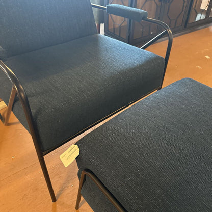 Two dark gray chairs with metal frames on a wooden floor.