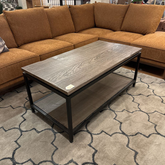 Brown sectional sofa with a coffee table on a patterned rug