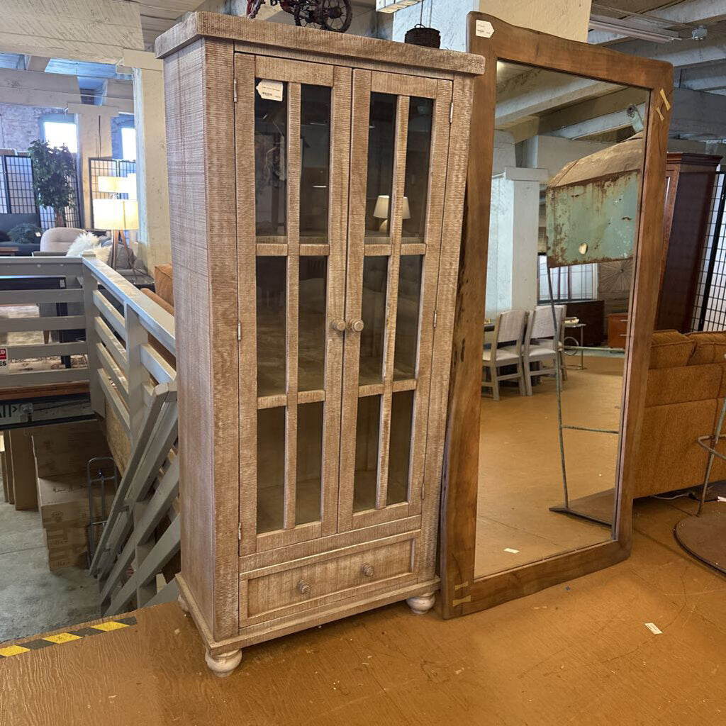 Wooden cabinet with glass doors in a warehouse setting