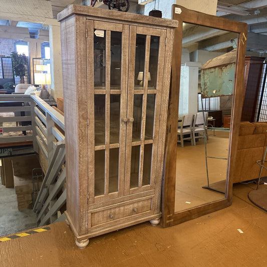 Wooden cabinet with glass doors in a warehouse setting