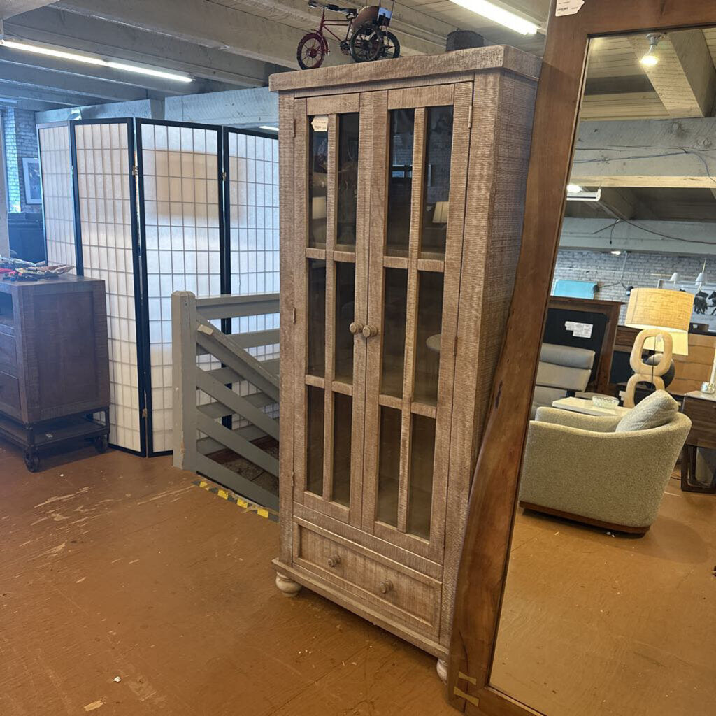 Wooden cabinet with glass doors in a warehouse setting