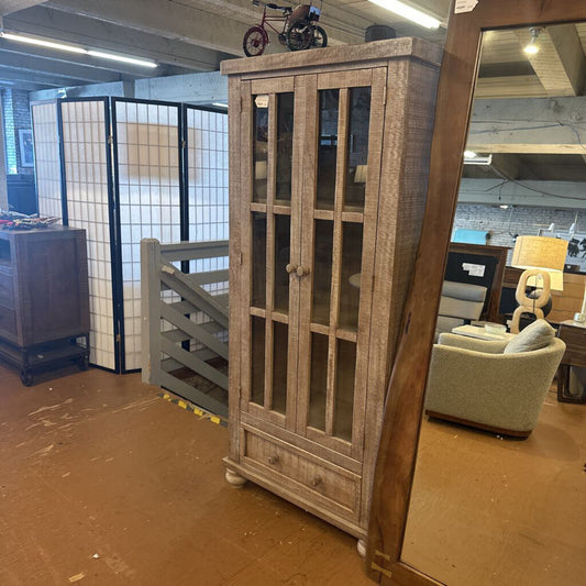 Wooden cabinet with glass doors in a warehouse setting