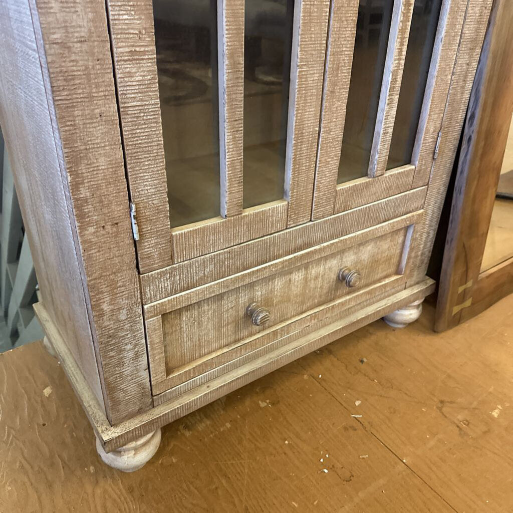 Wooden cabinet with glass panels on a wooden floor