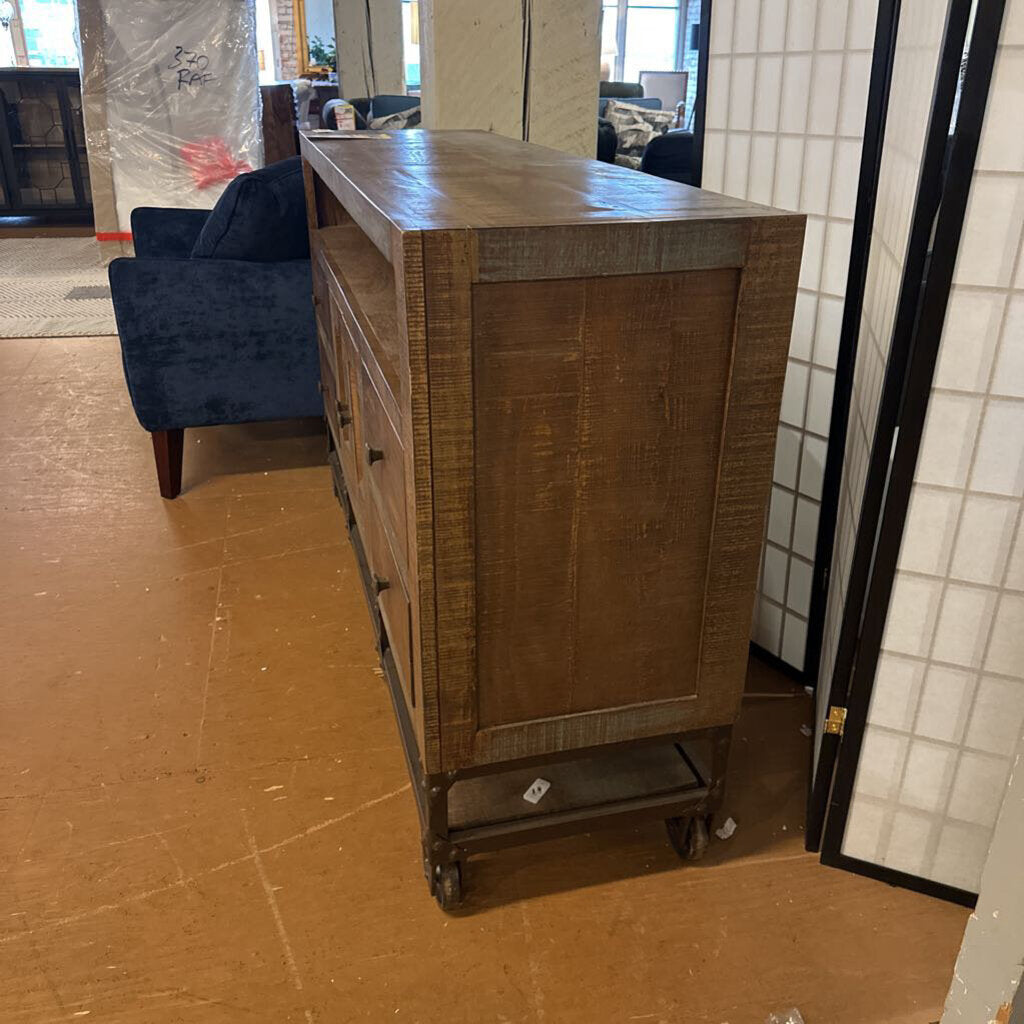 Wooden dresser in a room with tiled walls and a blue chair.