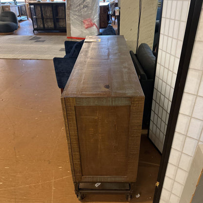 Wooden cabinet on wheels in a room with furniture and boxes