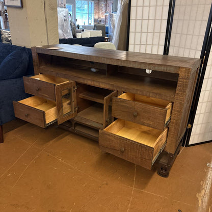 Wooden entertainment console with open drawers in a room setting