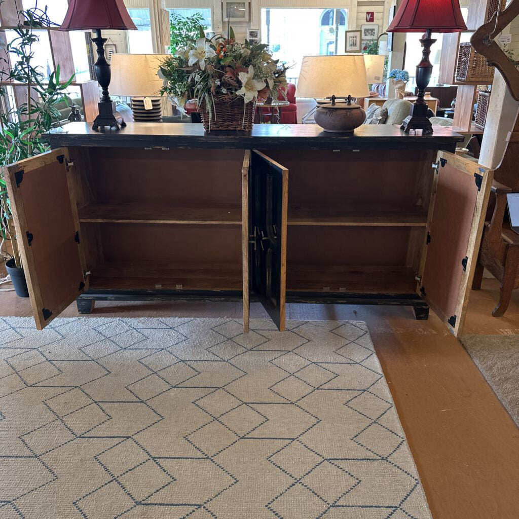 Large wooden cabinet with open doors in a room with lamps and decor.