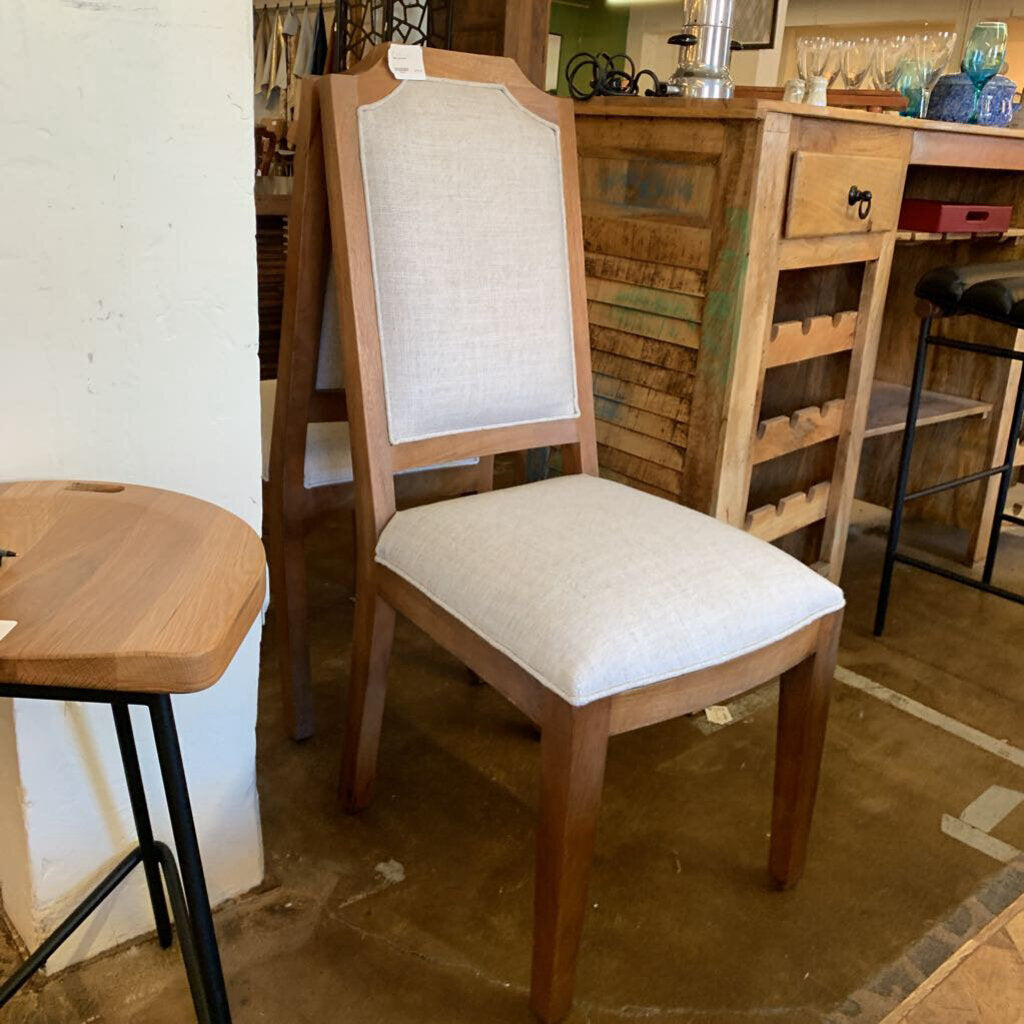 Wooden chair with white cushion in a store setting
