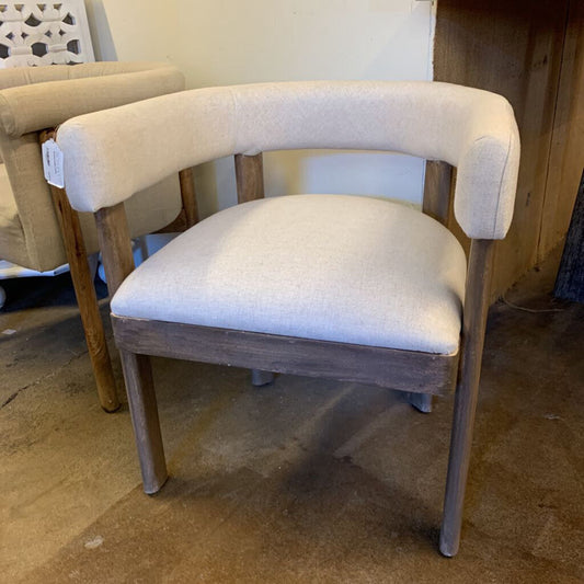 Chair with beige cushioned backrest and white seat in a storage or warehouse setting.