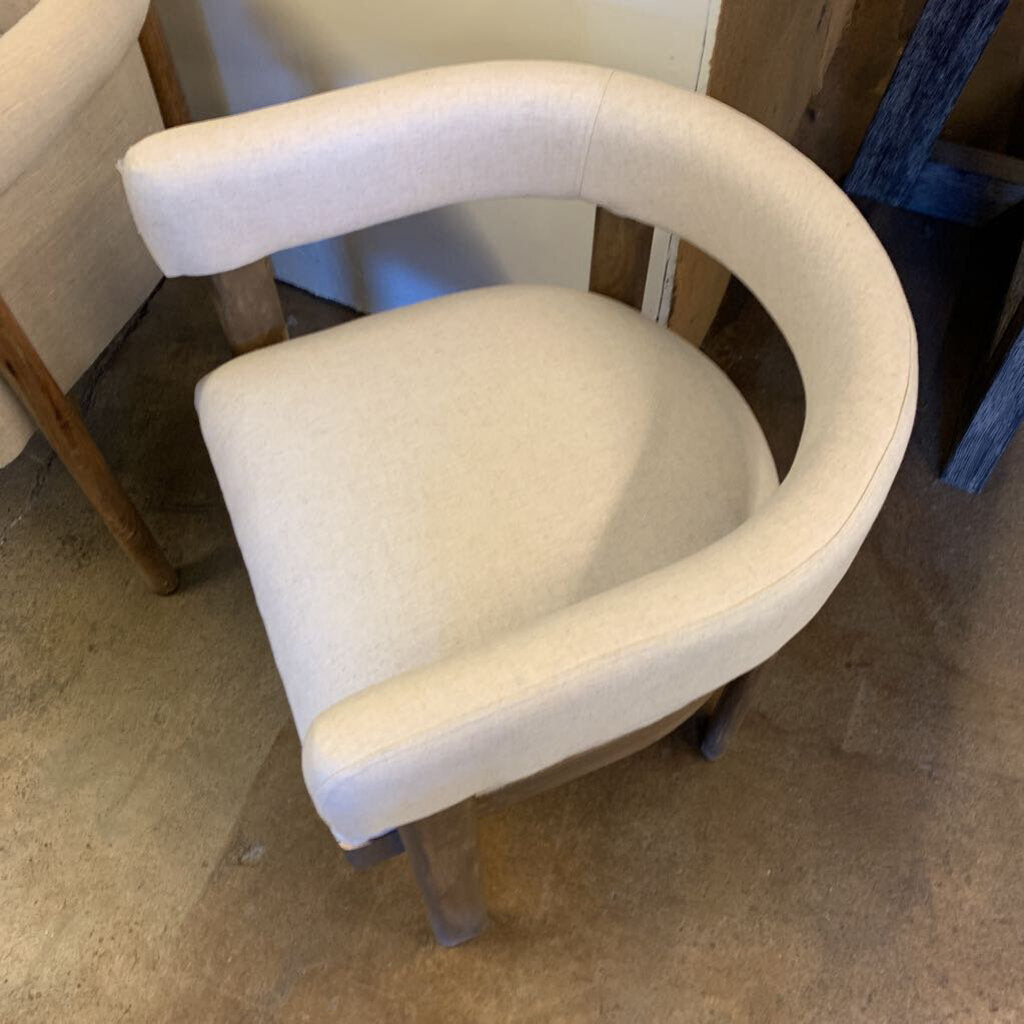 Beige armchair on a carpeted floor with a blurred background