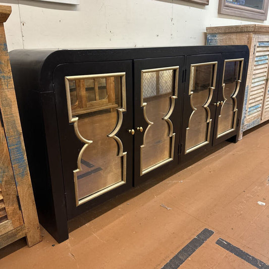 Long black cabinet with decorative mirrors in a warehouse setting