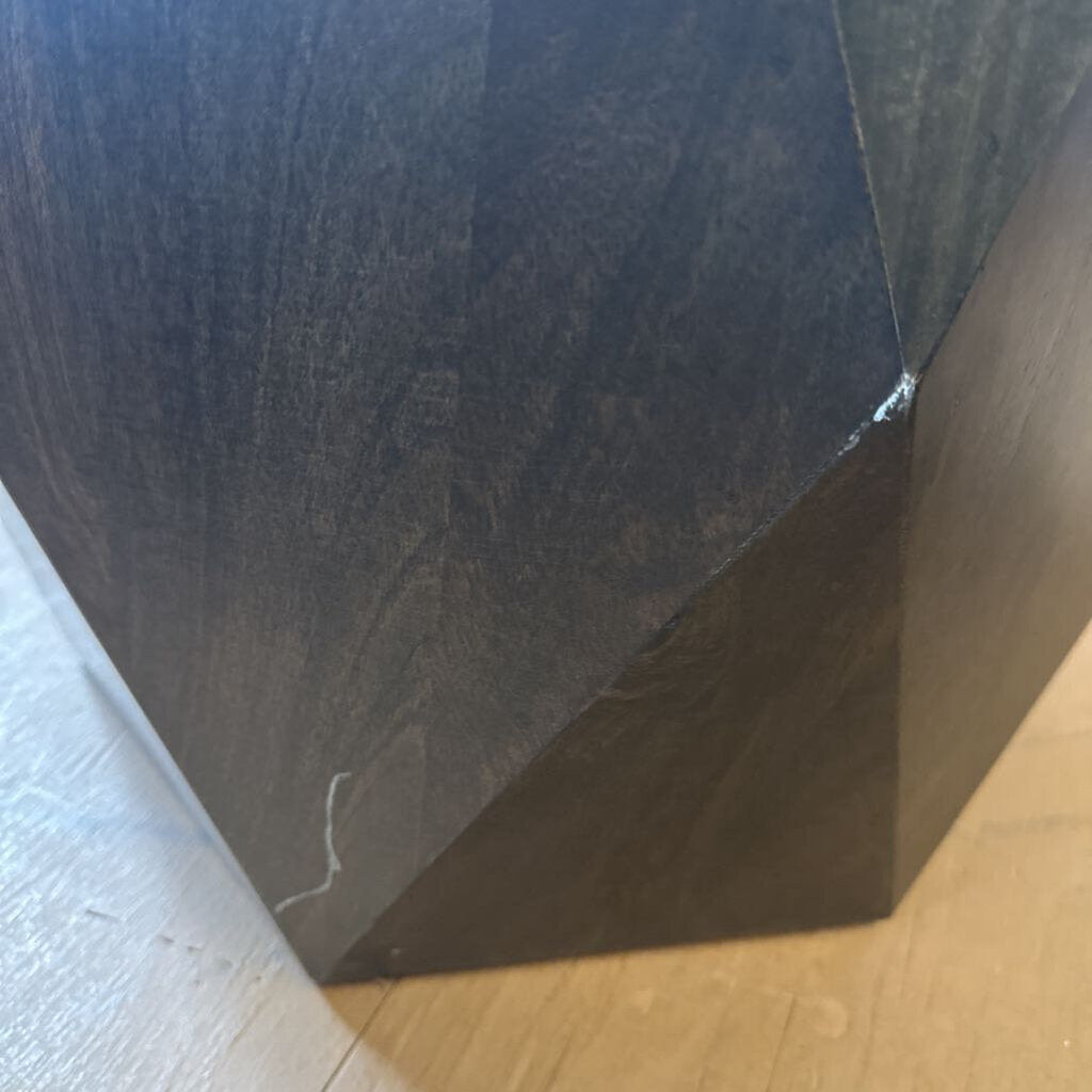 Close-up of a dark wooden surface with a visible grain pattern.
