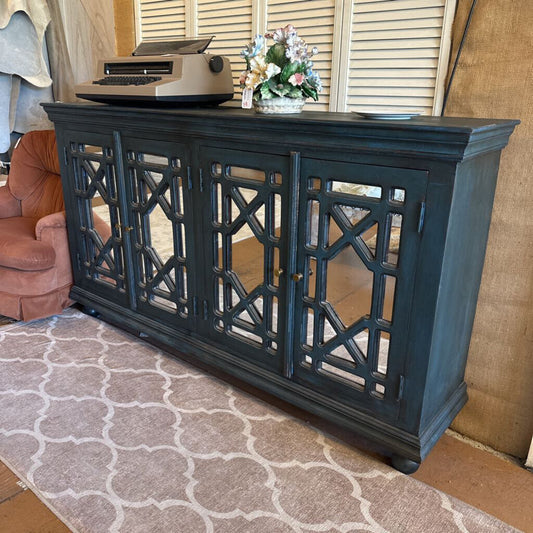 Dark blue decorative console table with intricate lattice design in a living room setting.