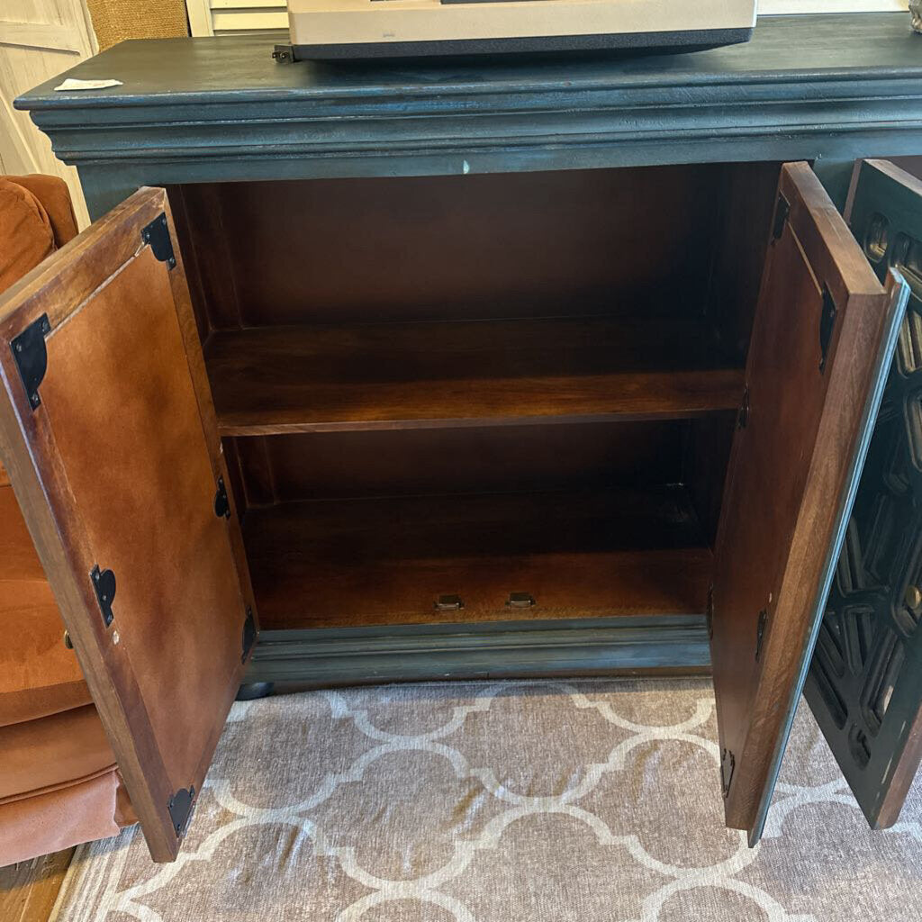 Wooden cabinet with open doors on a patterned rug