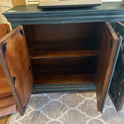 Wooden cabinet with open doors on a patterned rug