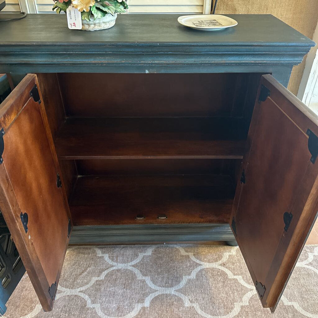 Wooden cabinet with open doors on a patterned rug