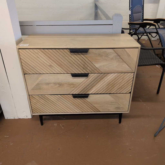 Wooden dresser with three drawers in a room setting